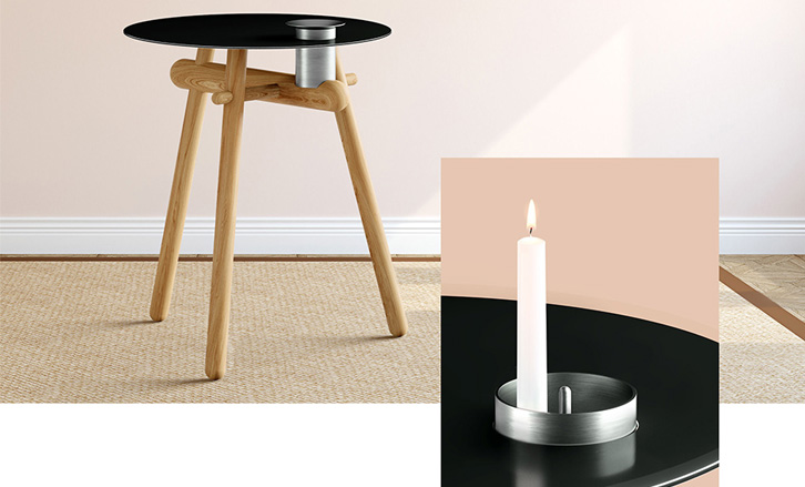 Une table ronde d'appoint avec un plateau noir ignifugé et un chandelier chromé.